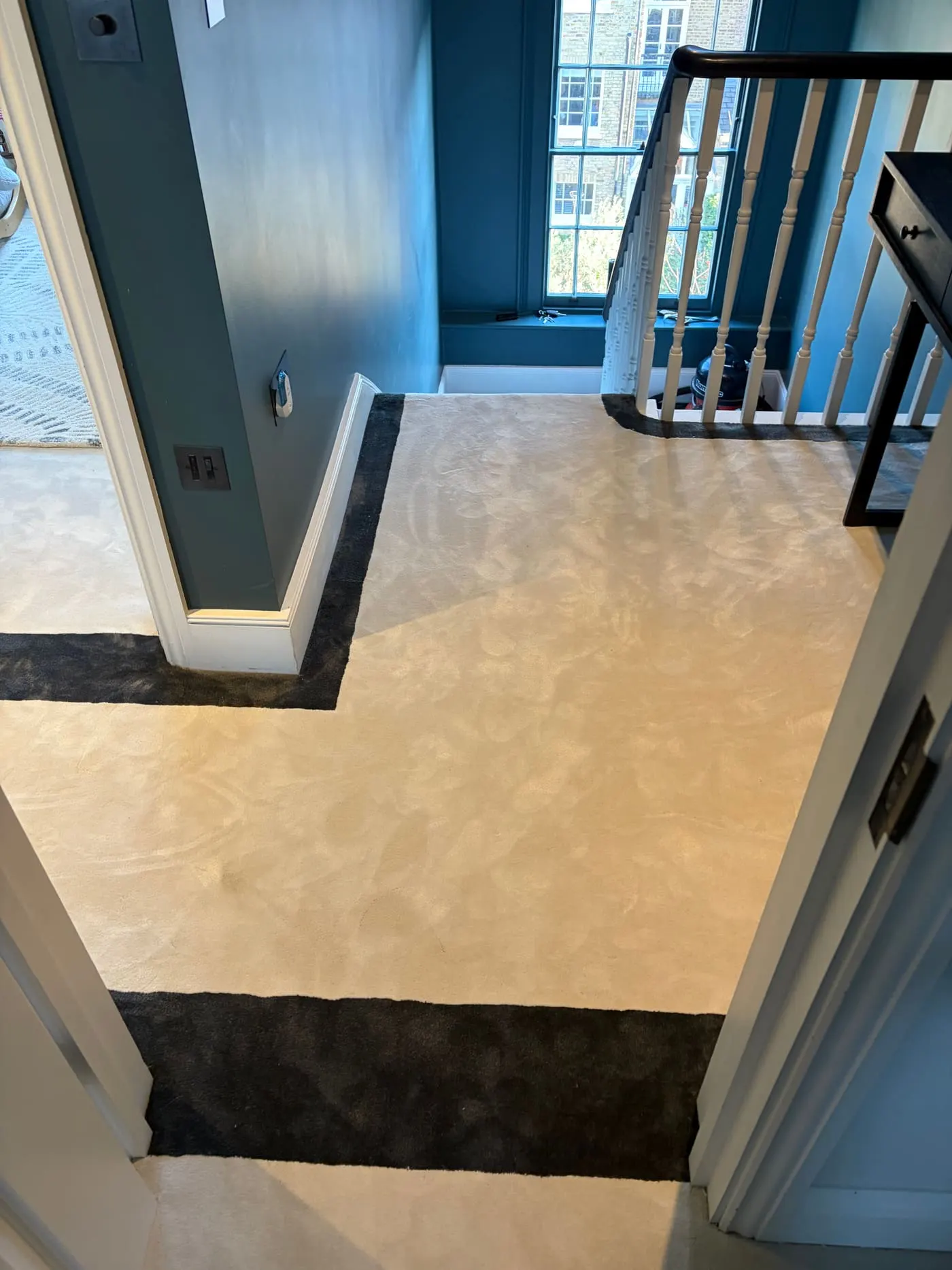 Cream carpet with black border fitted through a doorway on a landing