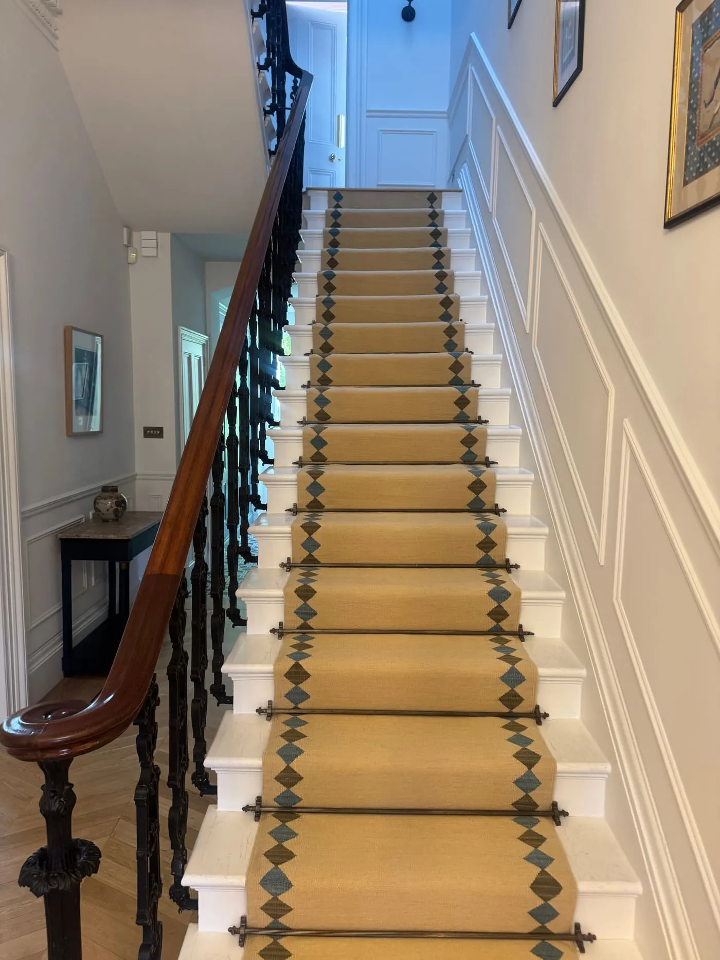 Cream stair runner with a teal and gold patterned border on a period staircase