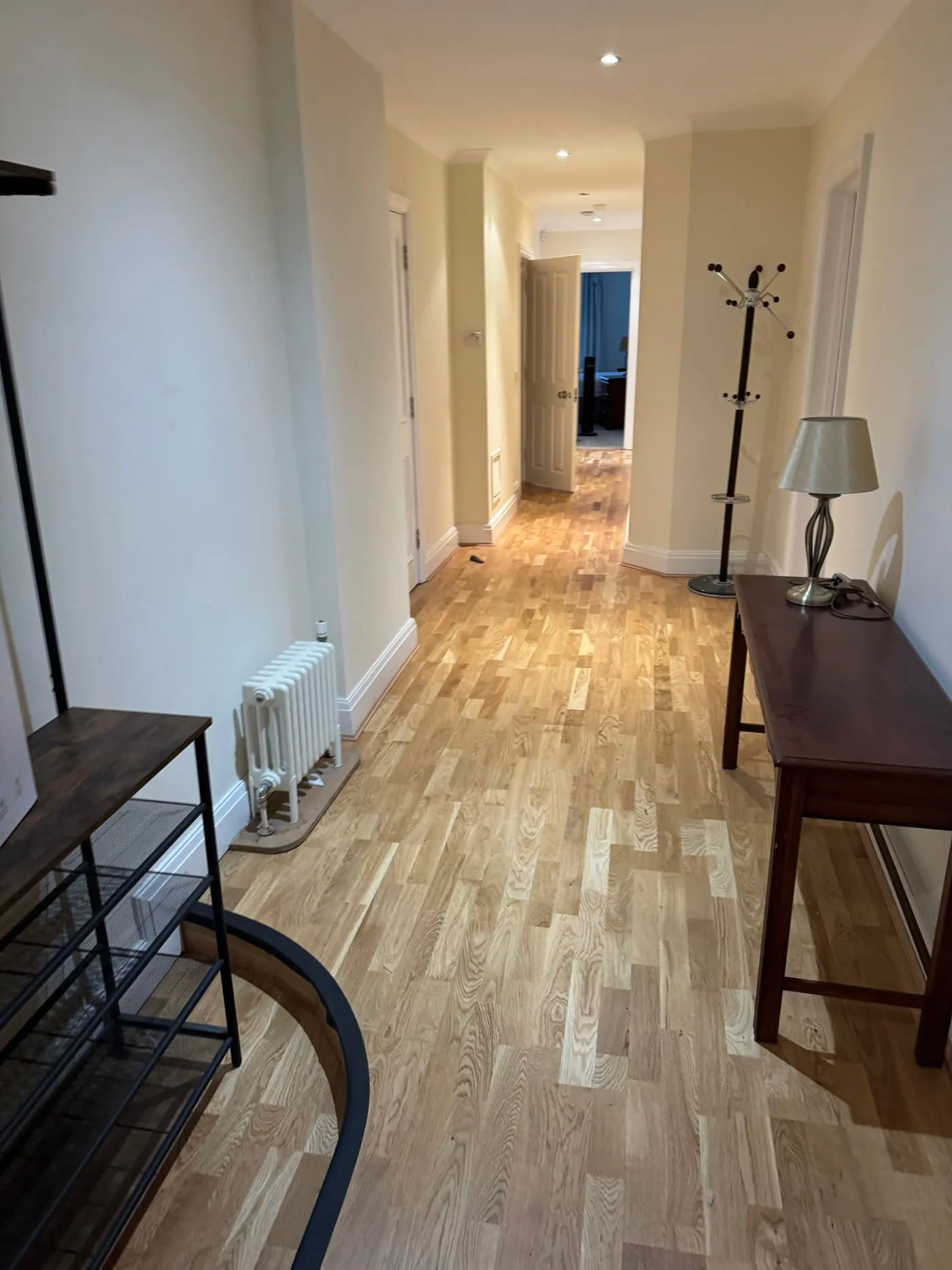 Light engineered oak plank flooring fitted along a long hallway