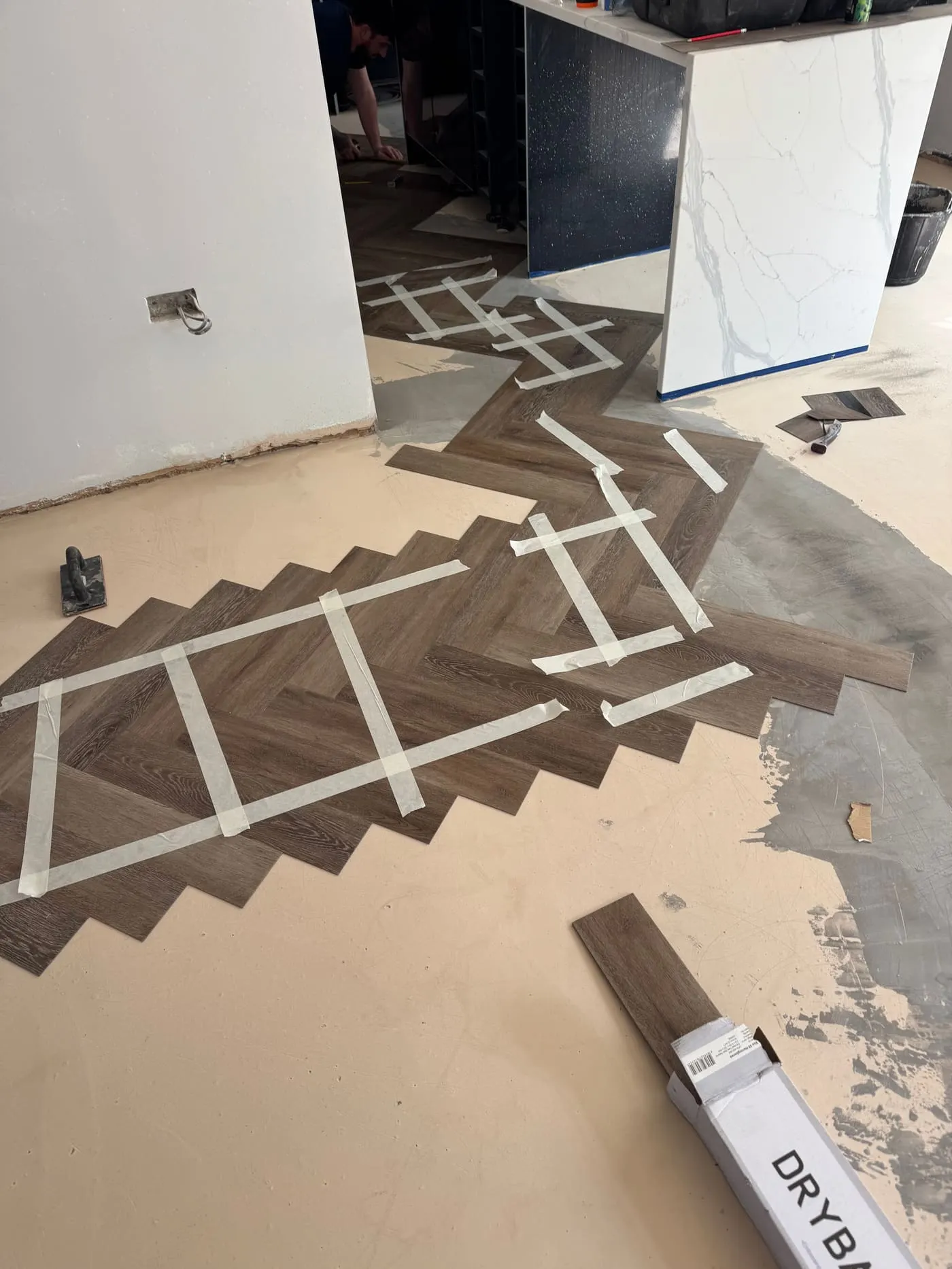 Herringbone parquet blocks being laid over a prepared subfloor