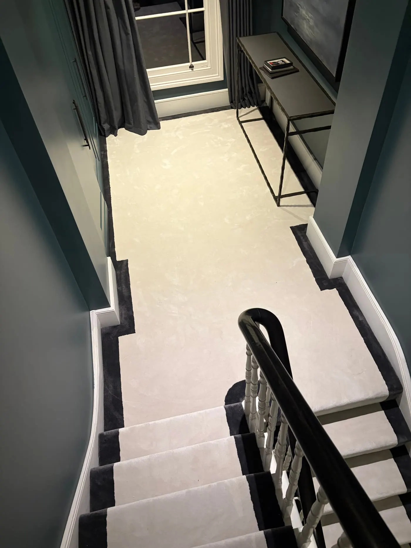 Cream landing carpet with black border meeting a matching stair runner
