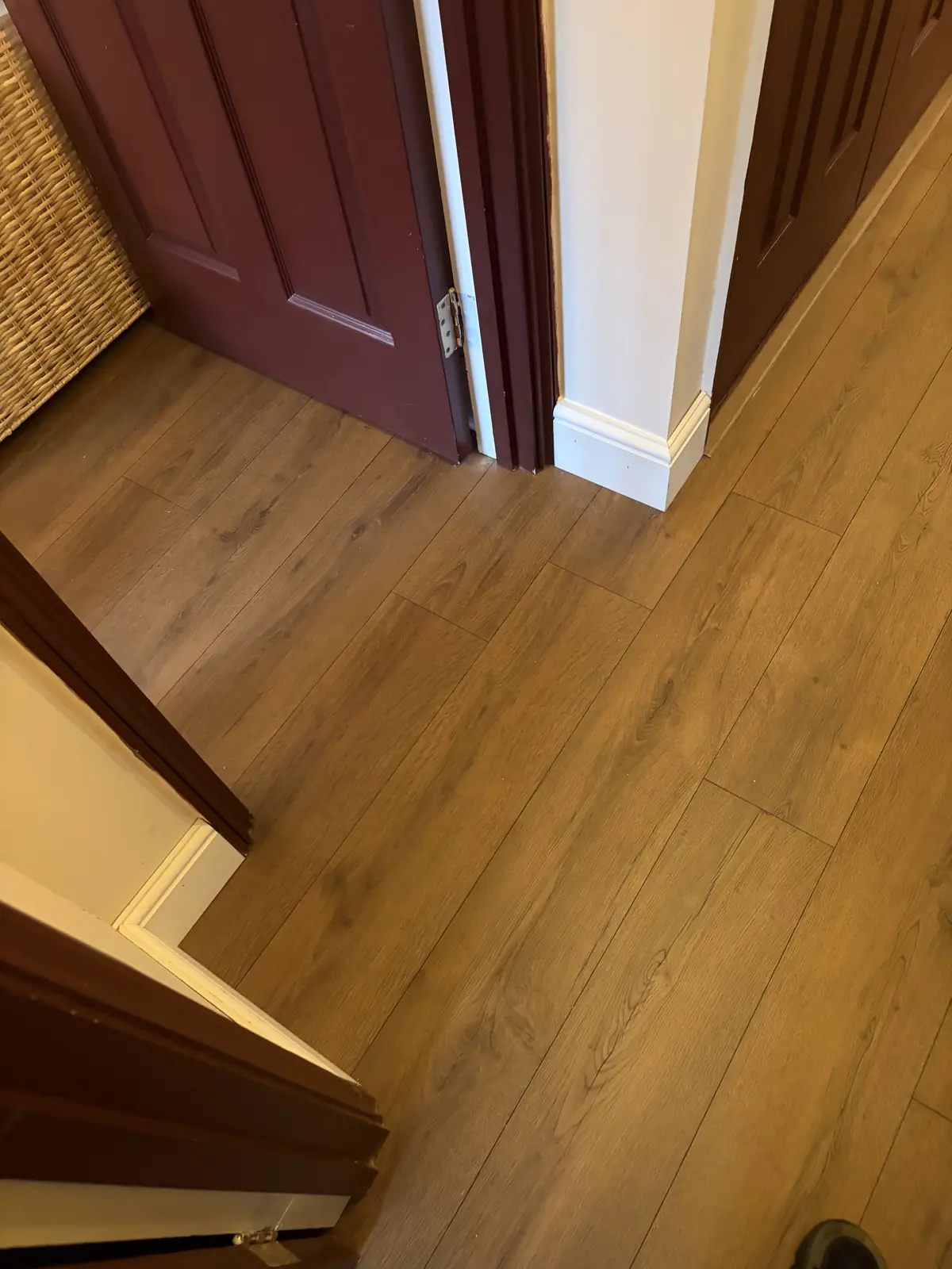 Oak-effect laminate flooring fitted through an interior doorway