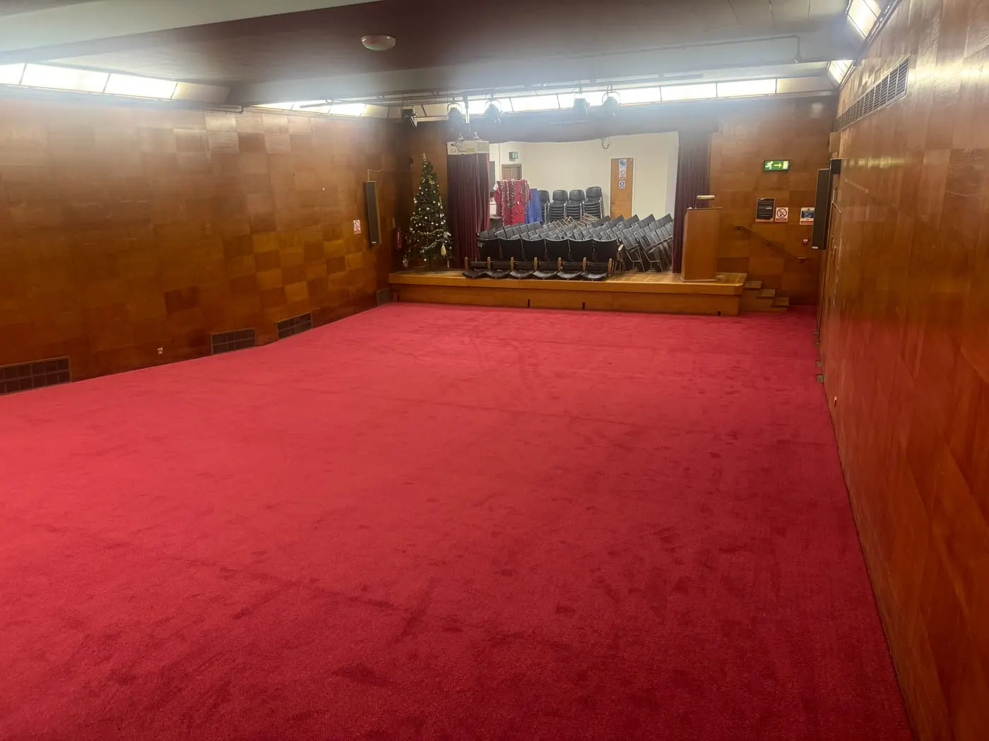 Large red carpet fitted in a wood-panelled function hall